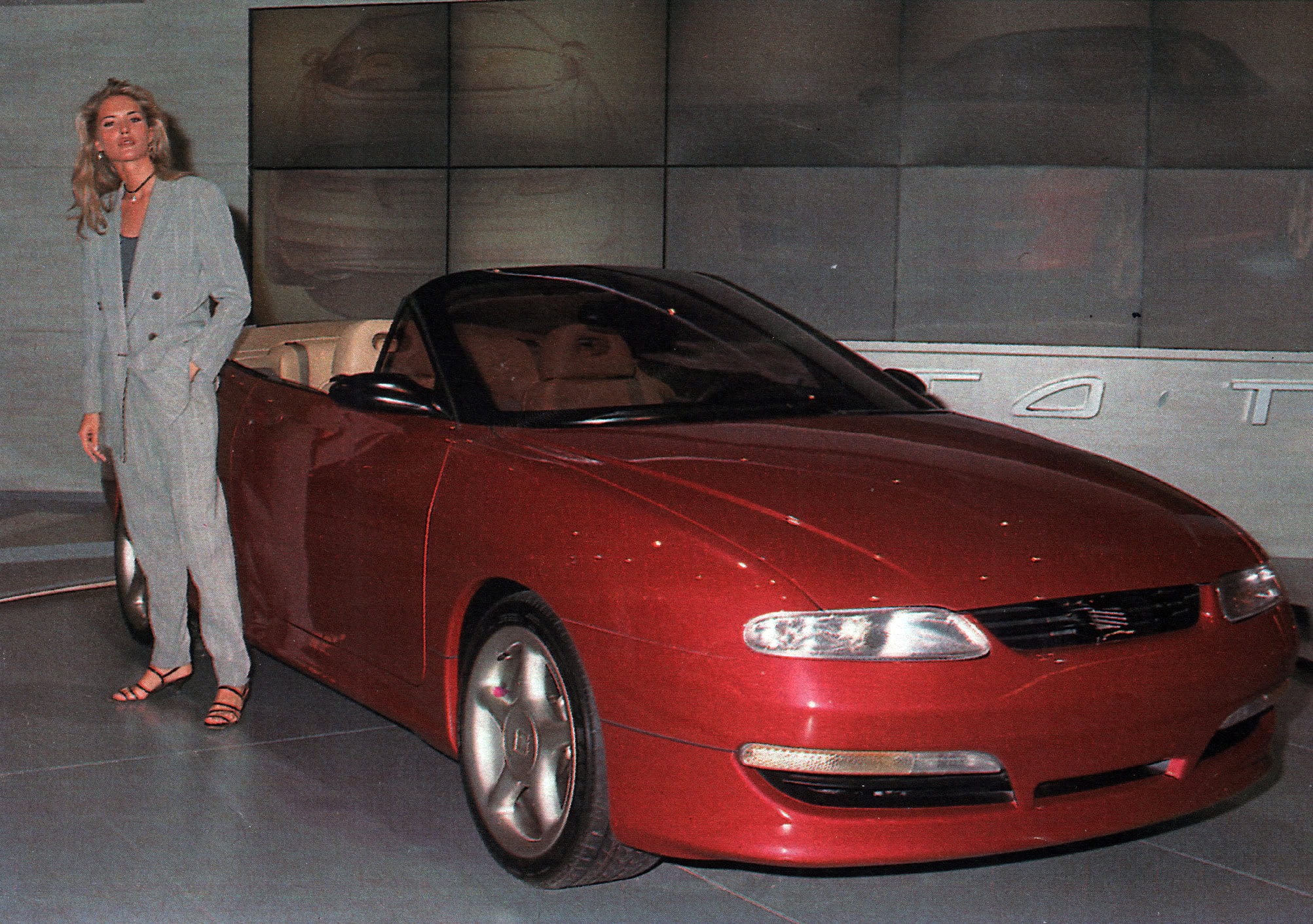 Auto de lujo rojo y mujer elegante en exposición.