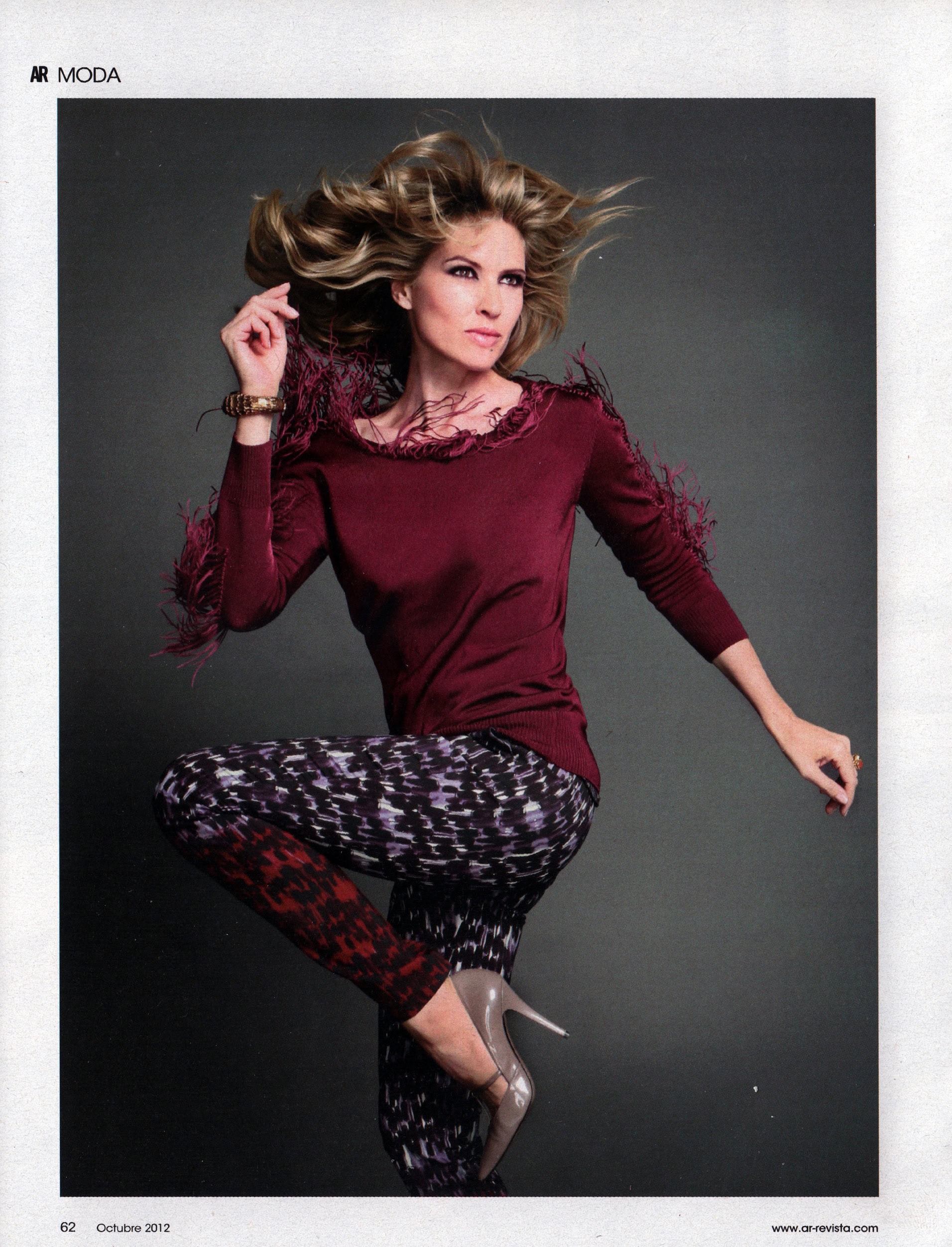 Mujer con cabello rizado y ropa de moda en sesión de fotos profesional.